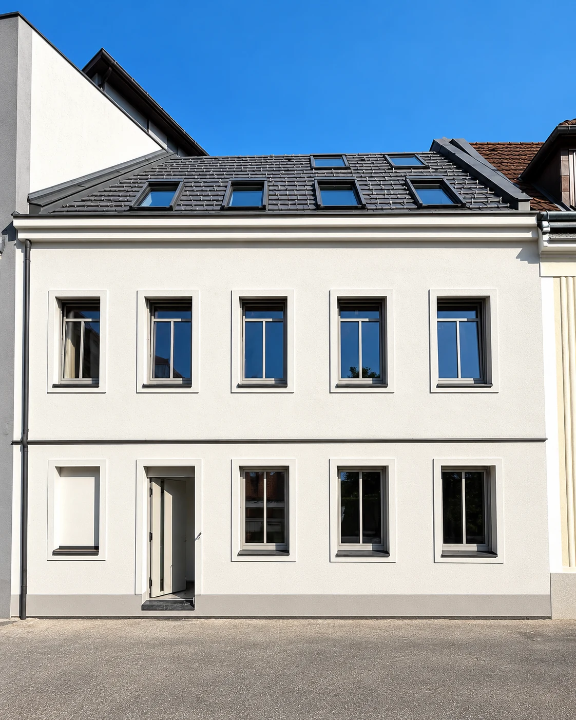 Helle Hausfassade mit grauen Aluminiumfenstern in St. Pölten